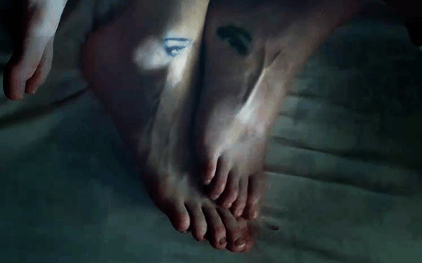 In one shot, we see the couple laying togheter with their feet displaying a matching tattoo ... of an eye. Although this appears to be a romantic thing, when we learn about the slave/handler relationship, the "all-seeing eye" tattoo takes on a disturbing meaning.