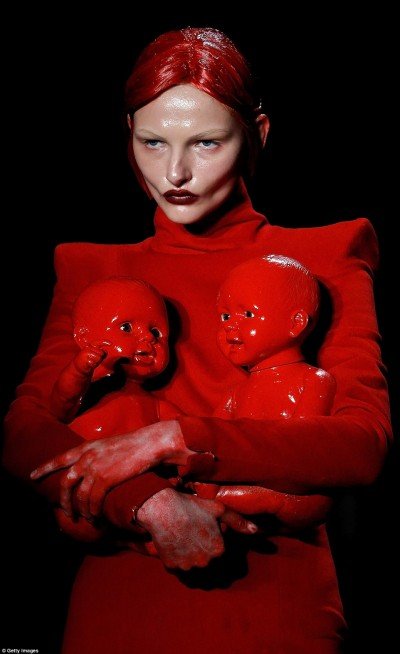 This model holds two dolls covered in fake blood. A sickening way to represent child sacrifice.