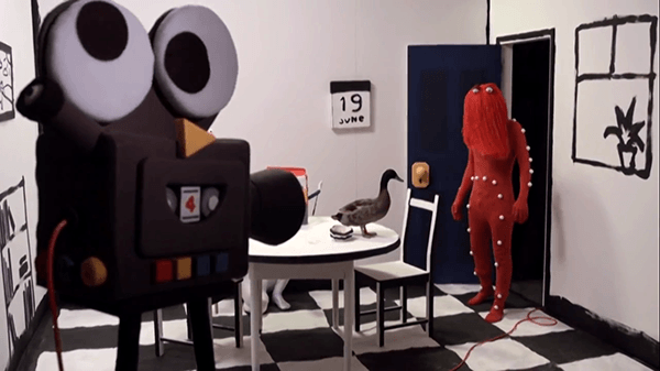 Red Guy finds himself in the "real world" (or a somewhat distorted version of it). He's an actor in a children's TV show that uses motion capture.