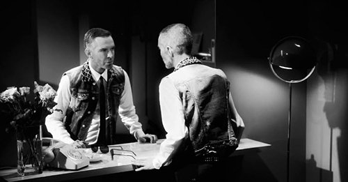 In the first scene, one of the brothers look at himself in the mirror (is his twin brother looking back at him?). The animal print collar appears to be a subtle reference to Kitten Programming).