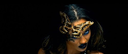 She has a huge butterfly covering one of her eyes, which is probably the most blatant reference to Monarch mind control in the video.