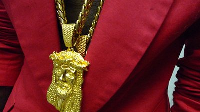 Kanye wearing a Jesus piece chain, a staple in hip-hop fashion. By displaying a melted down Jesus face on the album cover while naming the album "Yeezus", Kanye conveyed the fact that the symbol of Jesus is not an untouchable symbol of divinty and that he can also reach that status.
