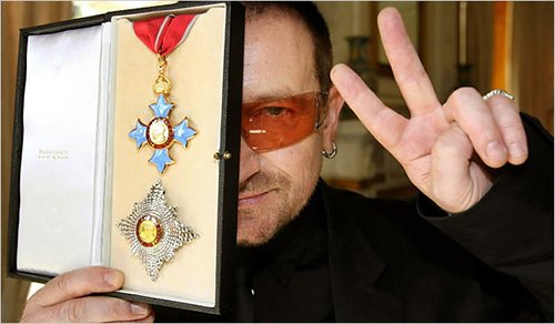 Bono showing off an award he received from Queen Elizabeth II...the same queen who have an award to mass abuser Jimmy Savile. Let's call this the occult elite award. And that's why Bono is hiding one eye with it. 