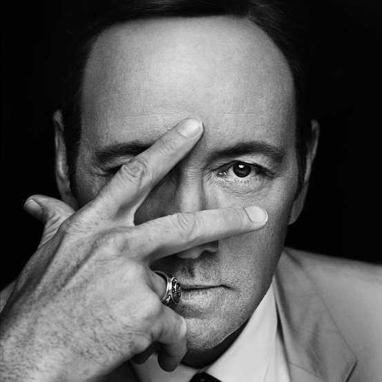 Here's Kevin Spacey promoting the second season of House of Cards. Yes, he is hiding on eye. Well, maybe its just a coincidence. He's just indicating the number two with his fingers and one of them accidentally hid his eye. And then the photographers chose that pic to be displayed everywhere. Its just a coincidence.