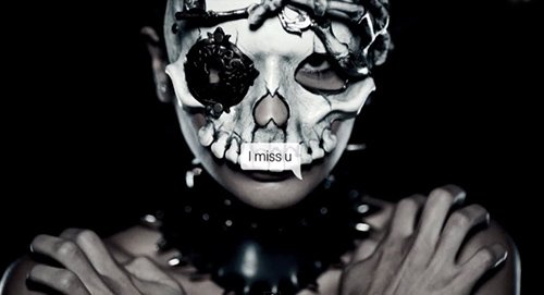 A skull head with one eye hidden. A clear way of saying : "This promotion of death culture was brought to you by the Illuminati entertainment business". The words "I miss you" can also mean that the business misses your soul.