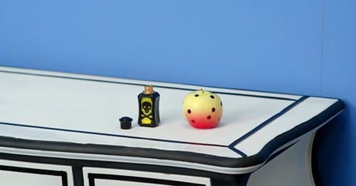 In this scene, we see a vial of poison turning a red apple yellow with black dots. This pattern will represent death throughout the rest of the video.