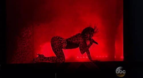 J-Lo on all fours while feline prints are projected on her. Yup, that's another nod to Kitten Programming.