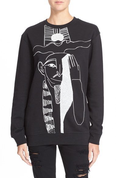 The one-eye sign is also on designer clothes, because it has to be considered cool and hip. This Alexander McQueen design features an Egyptian pharaoh doing it. 